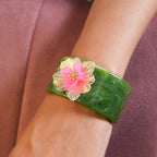 Marble-effect cuff bracelet with pink floral charm and gold-tone details