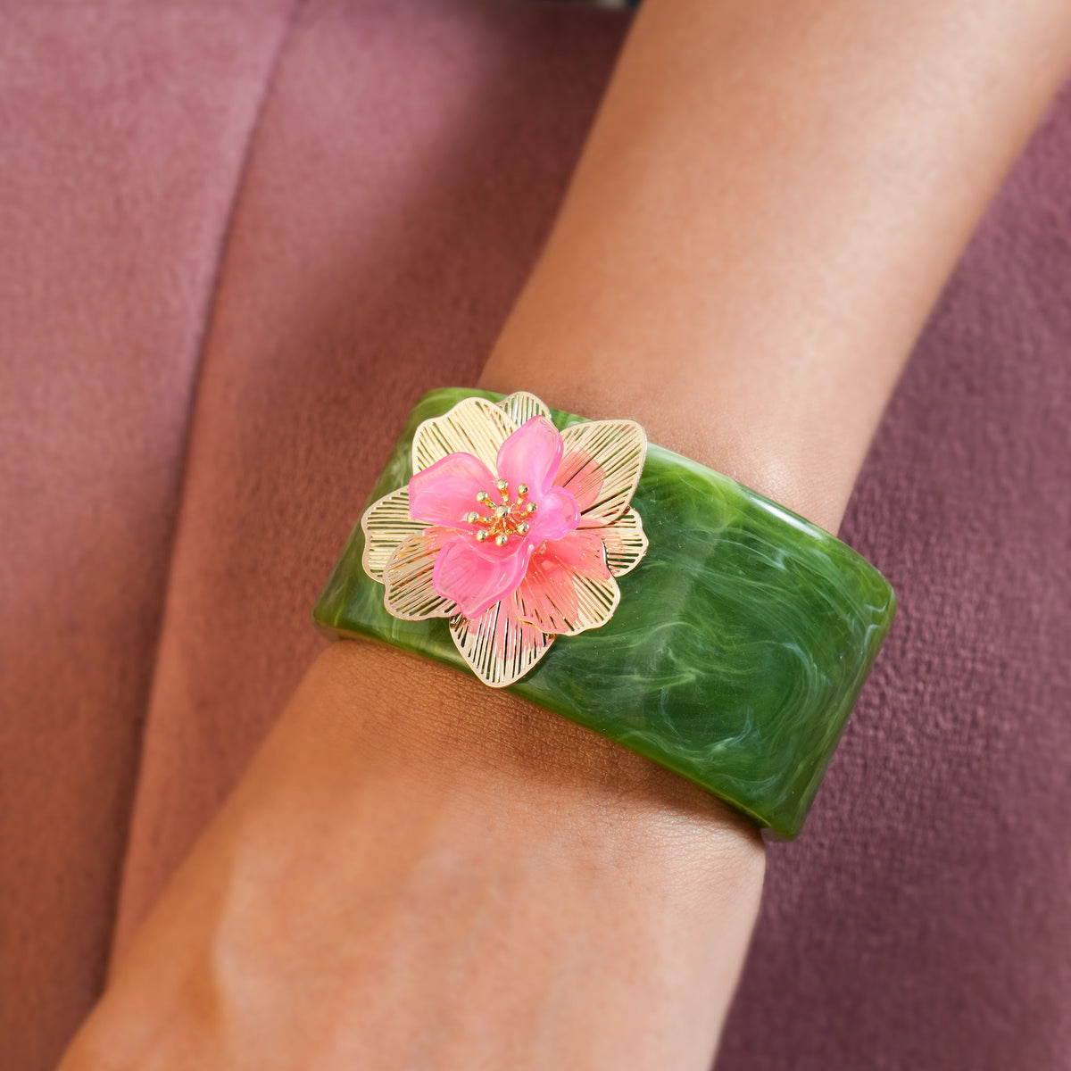 Marble-effect cuff bracelet with pink floral charm and gold-tone details
