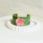 Marble-effect cuff bracelet with pink floral charm and gold-tone details
