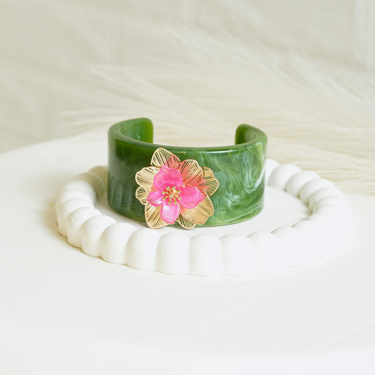 Marble-effect cuff bracelet with pink floral charm and gold-tone details
